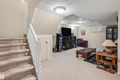 Carpeted stairs with white wooden railing - 8513 156 Avenue Nw, Edmonton, AB 