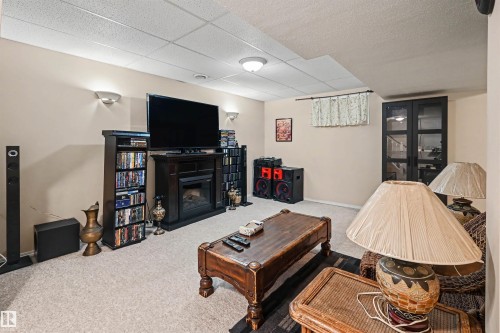 Recessed lighting, wall sconces, drop ceiling, carpeted flooring, and a built-in media console with a fireplace - 8513 156 Avenue Nw, Edmonton, AB 
