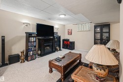 Recessed lighting, wall sconces, drop ceiling, carpeted flooring, and a built-in media console with a fireplace - 