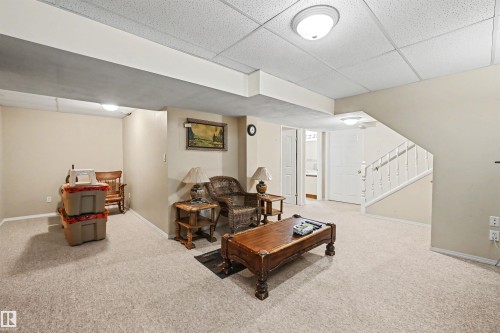 Recessed lighting, drop ceiling, carpet flooring, painted walls, and a finished staircase with white balusters - 8513 156 Avenue Nw, Edmonton, AB 