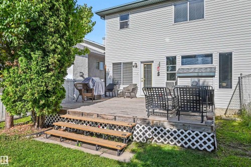 Expansive wood deck with lattice skirting, multiple steps, and a grassy yard - 8513 156 Avenue Nw, Edmonton, AB 