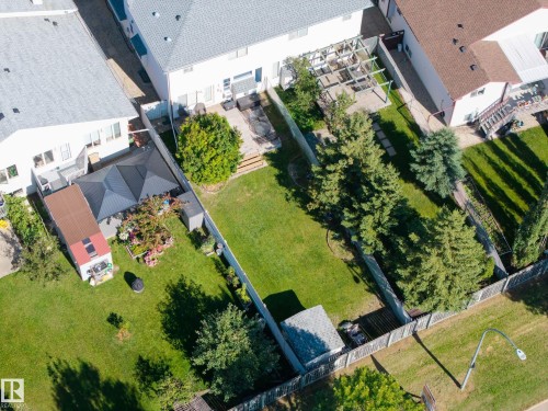 Expansive green lawn with mature trees and a fenced perimeter - 8513 156 Avenue Nw, Edmonton, AB 