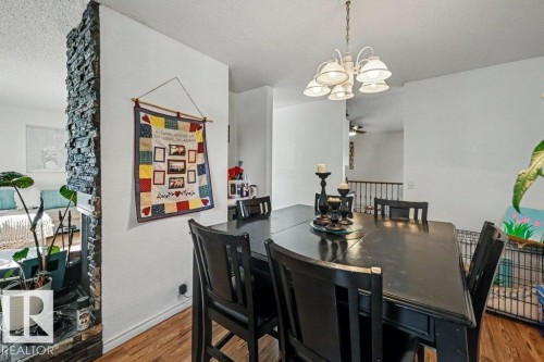 Wood-finish flooring throughout, complemented by a stone-faced partial wall - 8708 25A Avenue Nw, Edmonton, AB 