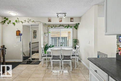 Tiled flooring extending throughout, window with horizontal blinds, built-in mirrored sliding closet doors, built-in white cabinetry, and recessed lighting - 8708 25A Avenue Nw, Edmonton, AB 