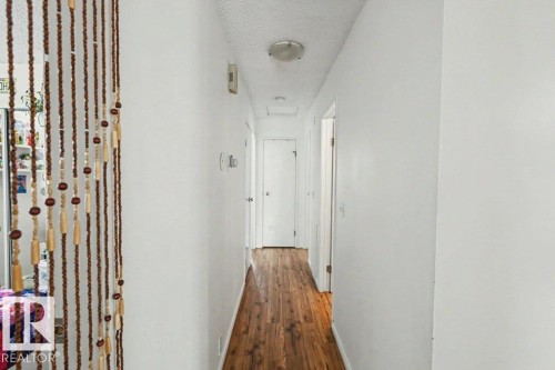 Wood-finish flooring with white walls and a flush-mount ceiling light fixture - 8708 25A Avenue Nw, Edmonton, AB 