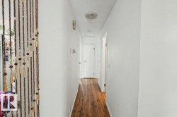 Wood-finish flooring with white walls and a flush-mount ceiling light fixture - 