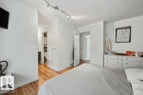 Hardwood-finish flooring, recessed track lighting, and a white interior door - 8708 25A Avenue Nw, Edmonton, AB 