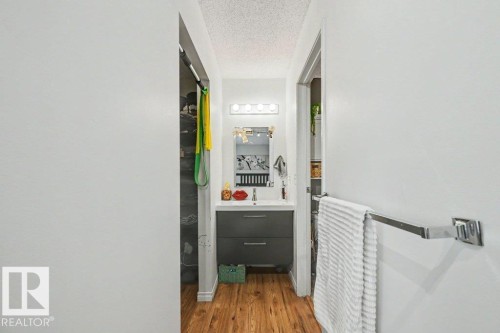 Vanity with integrated sink, two-drawer storage, and wood-finish flooring - 8708 25A Avenue Nw, Edmonton, AB 