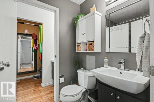 Modern vanity with a rectangular basin sink, chrome faucet, and dark wood-finish cabinetry - 8708 25A Avenue Nw, Edmonton, AB 