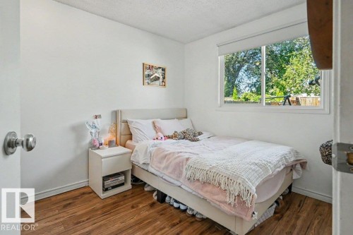 Wood-finish flooring, white walls, and a large window with roller shades - 8708 25A Avenue Nw, Edmonton, AB 