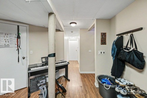 Wood-finish flooring throughout, featuring recessed ceiling lights and a neutral wall palette - 8708 25A Avenue Nw, Edmonton, AB 