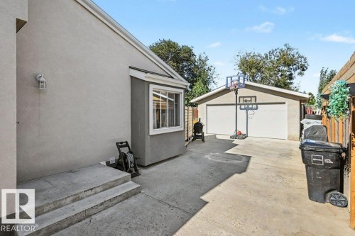Detached garage with a double-width door and concrete driveway - 8708 25A Avenue Nw, Edmonton, AB 