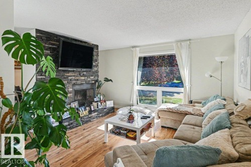 Stacked stone fireplace with a black firebox and hearth - 8708 25A Avenue Nw, Edmonton, AB 