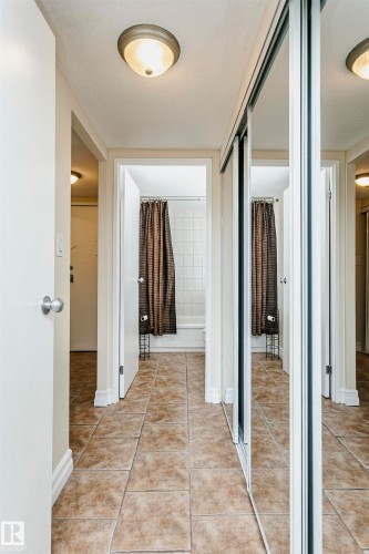 Tiled flooring entryway with mirrored sliding closet doors - #815 10160 114 St Nw, Edmonton, AB 