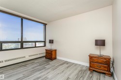 Expansive window offering broad outdoor scenery, light gray wood-finish flooring, and neutral wall paint - 