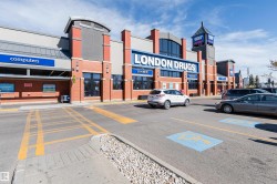 Brick facade with large display windows, prominent retail signage, and a multi-level roofline - 