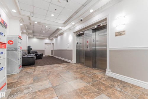 Tiled flooring entry with recessed lighting, crown molding, and two stainless steel elevators - #815 10160 114 St Nw, Edmonton, AB 
