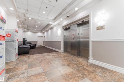 Tiled flooring entry with recessed lighting, crown molding, and two stainless steel elevators - 