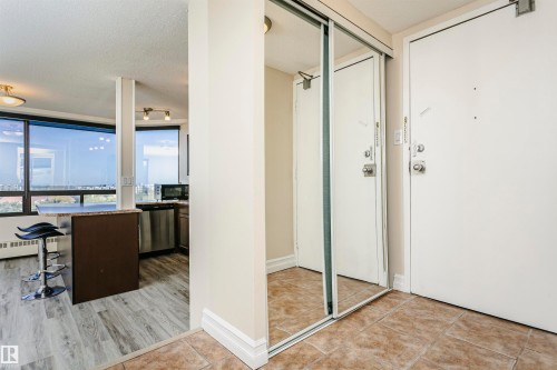 Mirrored closet doors, light-toned tile flooring, wood-finish flooring, full-height windows, and stainless steel appliances - #815 10160 114 St Nw, Edmonton, AB 