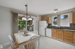 Eat-In Kitchen with light wood-finish cabinetry, a patterned tile backsplash, and a sliding glass door leading to an outdoor deck - 