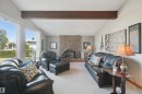 Vaulted ceilings with exposed wood beams, a brick facing gas fireplace and large windows - 11439 144 Avenue Nw, Edmonton, AB 