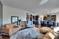 Hardwood-finish flooring throughout, dark wood cabinetry, stainless steel appliances, and pendant lighting - 