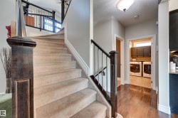 Carpeted staircase with dark wood newel post and balusters - 