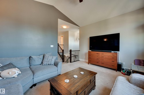 Carpeted flooring, vaulted ceiling, and painted walls create a comfortable living area - 2203 Warry Loop Sw, Edmonton, AB 