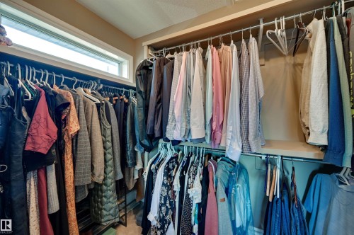 Built-in closet organization system featuring multiple hanging rods and a clerestory window - 2203 Warry Loop Sw, Edmonton, AB 