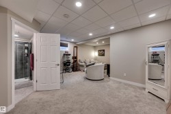 Recessed lighting illuminates the carpeted living area with a drop ceiling - 