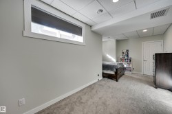 Recessed lighting illuminates the carpeted flooring and light-toned walls - 