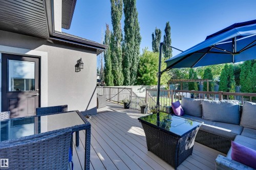 Expansive composite deck with dark wood railing and a built-in outdoor wall lantern - 2203 Warry Loop Sw, Edmonton, AB 