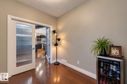 Hardwood-style flooring, white trim, and a glass-paneled door - 