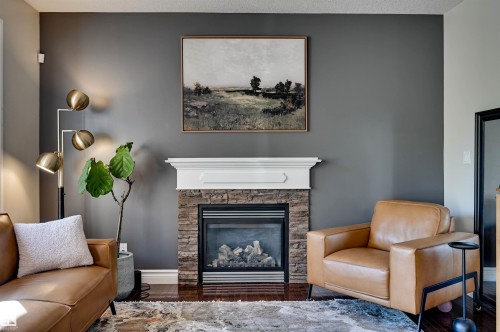 Gas fireplace with a stone surround and classic white mantel - 2203 Warry Loop Sw, Edmonton, AB 