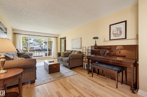 Hardwood flooring, expansive window, neutral wall paint, and a textured ceiling - 30 Gariepy Crescent Nw, Edmonton, AB 