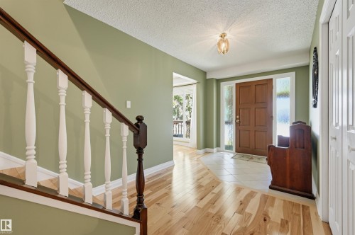 Foyer with a paneled wood entry door, sidelight windows, and a ceiling-mounted light fixture - 30 Gariepy Crescent Nw, Edmonton, AB 