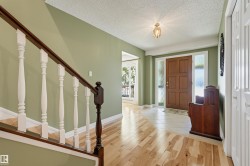 Foyer with a paneled wood entry door, sidelight windows, and a ceiling-mounted light fixture - 