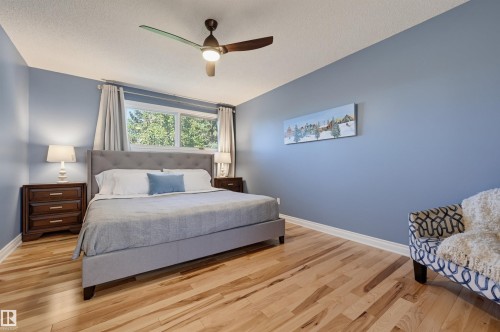 Light wood-finish flooring, tufted headboard, and a ceiling fan with integrated lighting - 30 Gariepy Crescent Nw, Edmonton, AB 