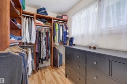 Custom closet organization system with wood-finish shelving and hanging rods - 