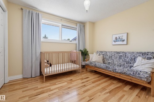Hardwood flooring, painted walls, a double window with blinds, and a paneled door - 30 Gariepy Crescent Nw, Edmonton, AB 