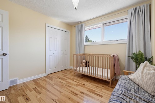 Hardwood flooring, dual pane windows, bi-fold closet doors, white trim, and a ceiling-mounted light fixture - 30 Gariepy Crescent Nw, Edmonton, AB 