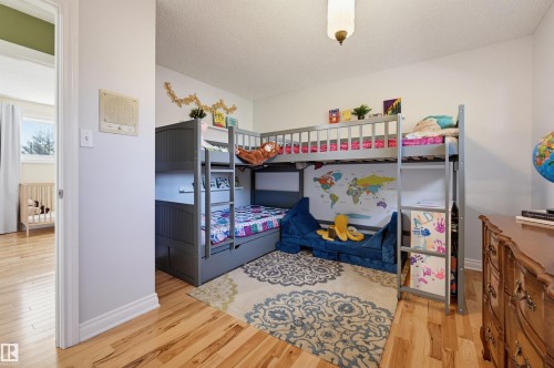 Light wood-finish flooring with a decorative area rug - 30 Gariepy Crescent Nw, Edmonton, AB 
