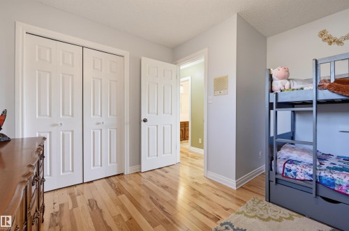 Wood-finish flooring throughout, bright white trim, and a white six-panel door - 30 Gariepy Crescent Nw, Edmonton, AB 