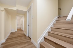 Wood-finish flooring throughout, white trim, and light neutral wall colors - 