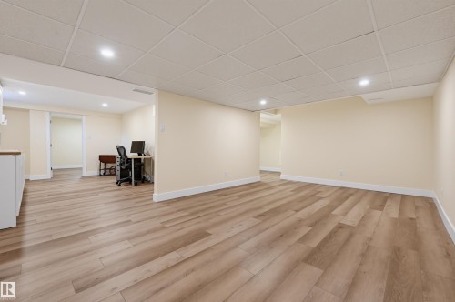 Spacious room featuring wood-finish flooring, recessed lighting, and a drop ceiling - 30 Gariepy Crescent Nw, Edmonton, AB 