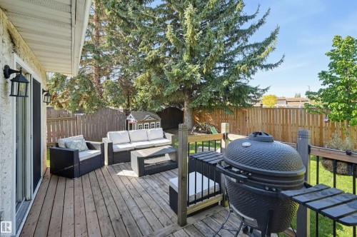 Wood-finish deck with a privacy fence, exterior wall sconces, and mature trees - 30 Gariepy Crescent Nw, Edmonton, AB 