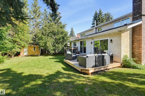 Expansive grassy backyard featuring a built-in wooden deck and a detached storage shed - 30 Gariepy Crescent Nw, Edmonton, AB 