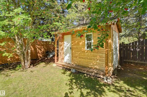 Wood-sided shed with a single window and small porch - 30 Gariepy Crescent Nw, Edmonton, AB 