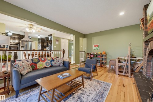 Hardwood flooring, brick fireplace with tile hearth, recessed ceiling lighting, and a ceiling fan in the kitchen area - 30 Gariepy Crescent Nw, Edmonton, AB 