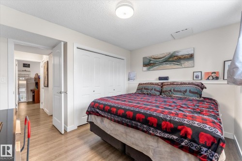 Light-colored wood-finish flooring, white bi-fold closet doors, and recessed wall shelving - 16012 98 Avenue Nw, Edmonton, AB 